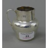 A Mappin and Webb silver cream jug. 7 cm high. 100 grammes.