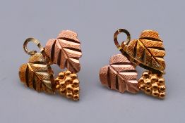 A pair of 10 K gold grape leaf form earrings. 1.5 cm high.