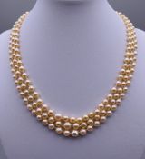 A three strand pearl necklace with a 9 ct gold clasp. Approximately 40 cm long.