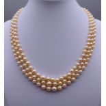 A three strand pearl necklace with a 9 ct gold clasp. Approximately 40 cm long.