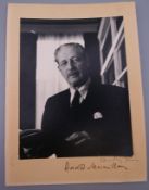 A photograph of Harold Macmillan, on folded card, signed to margin. Image 14.5 cm x 11 cm.