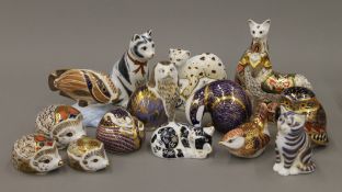 A collection of Royal Crown Derby paperweights including cats, bird, owl, hedgehogs, ram, fish, etc.