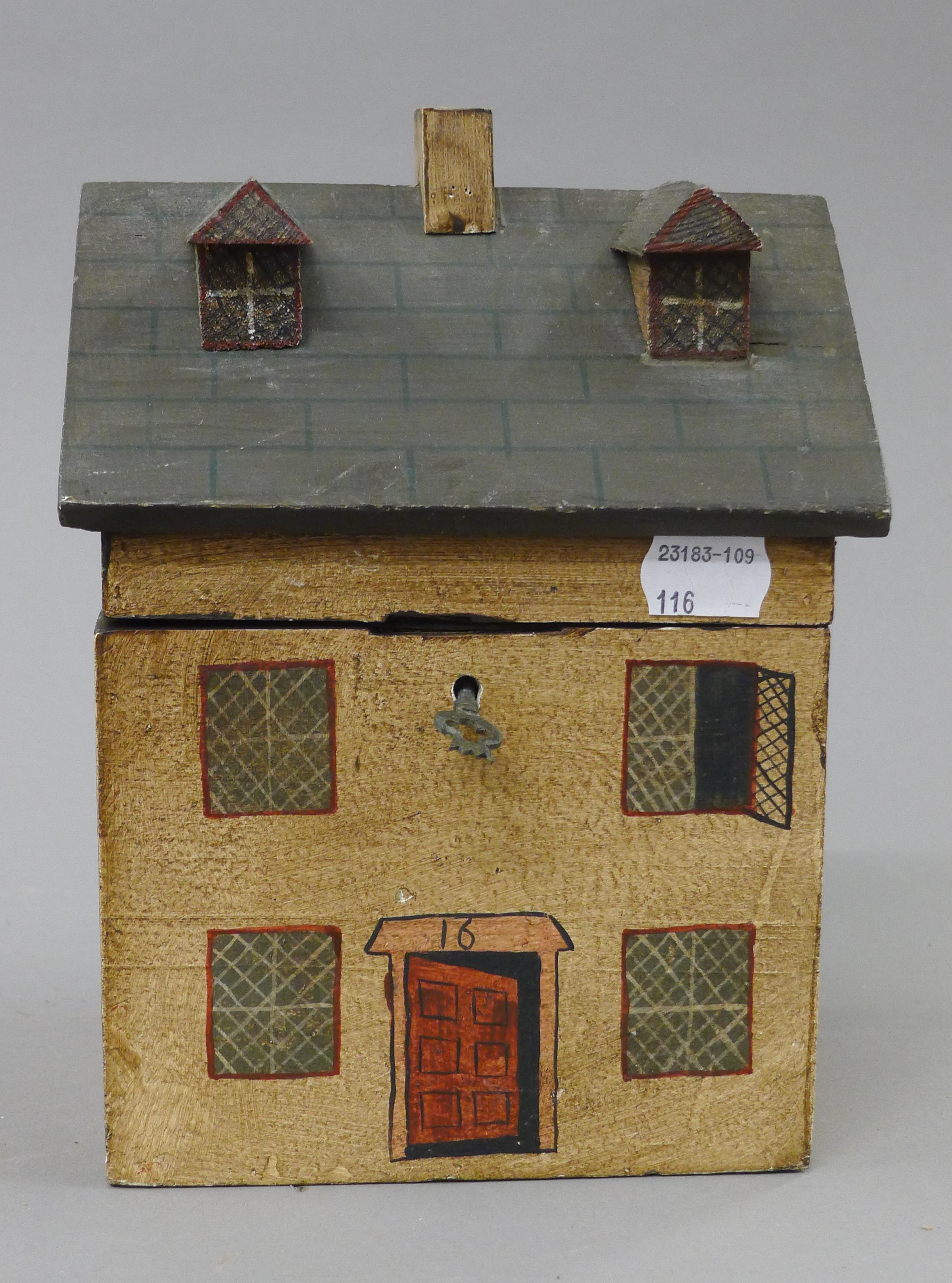 A house formed painted wooden box. 21 cm high.
