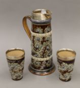 A Doulton Lambeth silver mounted jug and a pair of matching beakers.