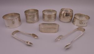 Six silver napkin rings and two pairs of silver tongs. Largest napkin ring 3.