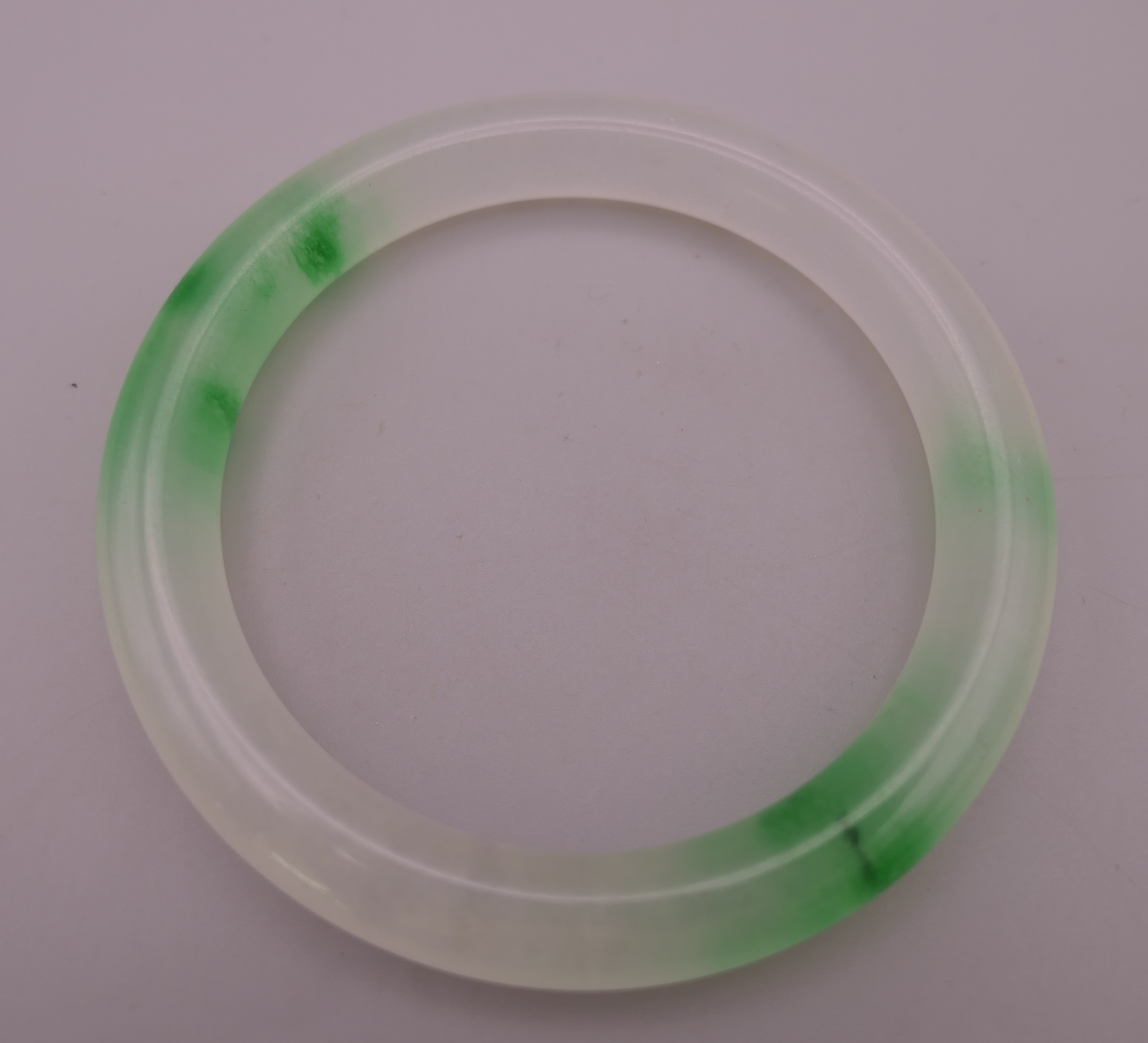 A two tone jade bangle. 5.5 cm inner diameter.