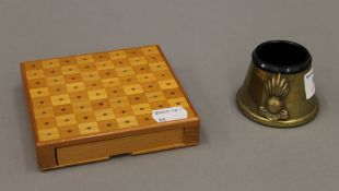 A travelling chess set and a Trench Art inkwell.