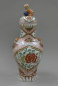 A porcelain lidded vase, the finial formed as a dog of fo. 57 cm high.