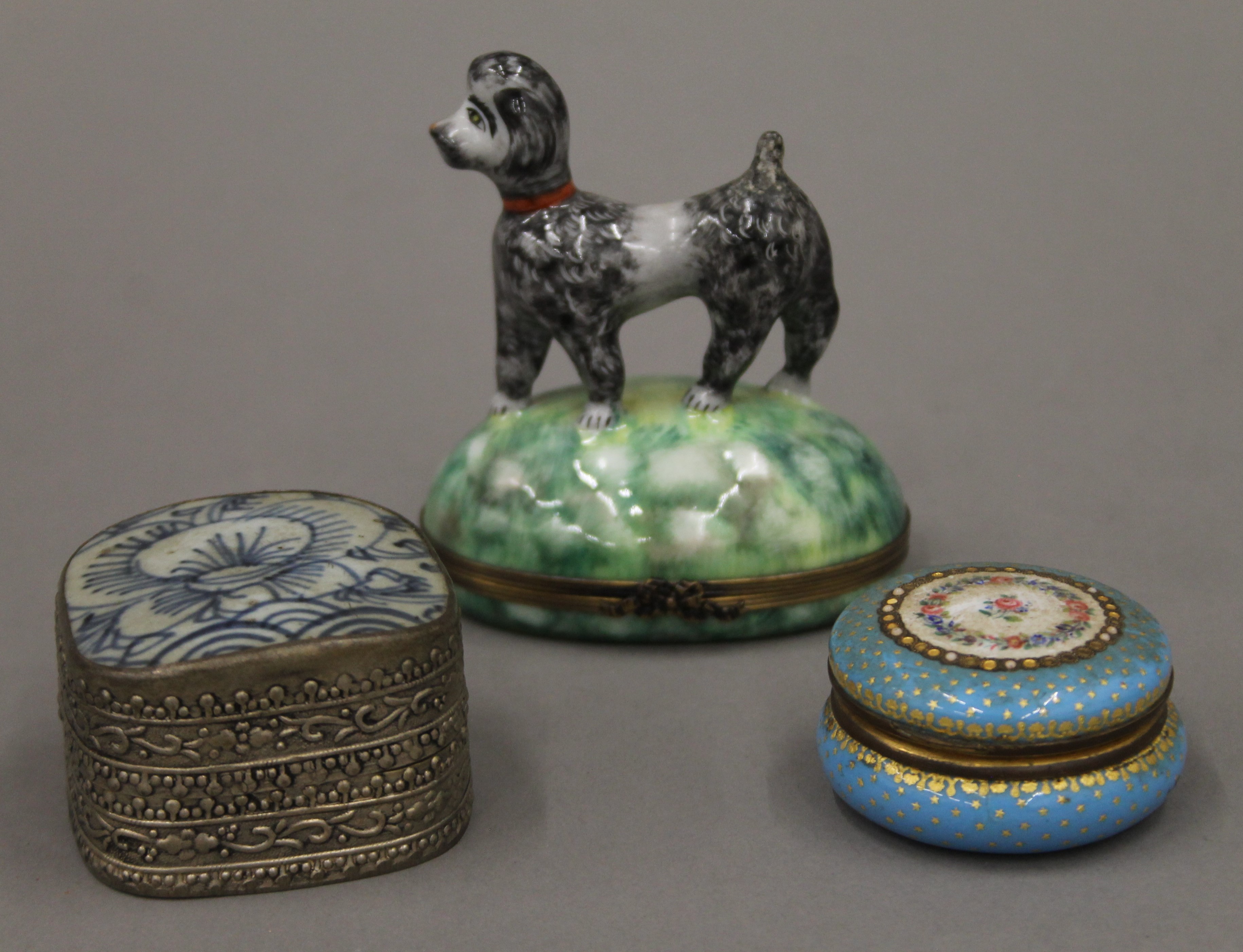 A Limoges porcelain box surmounted with a dog and two other boxes. The former 9 cm high.