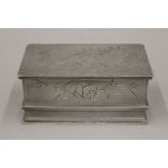 An early 20th century Chinese pewter cigar box with dragon decoration to the lid,