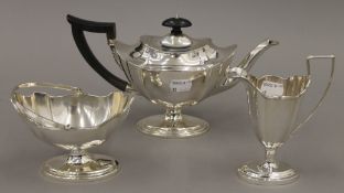 A three-piece Scottish silver tea set by Hamilton and Inches. The tea pot 26 cm long. 778.