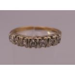 A 9 ct gold seven stone diamond ring. Ring size T (shank split). 3 grammes total weight.