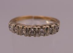 A 9 ct gold seven stone diamond ring. Ring size T (shank split). 3 grammes total weight.