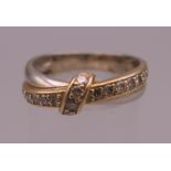 A 14 K bi-colour gold diamond cross over ring. Ring size O/P. 4.5 grammes total weight.