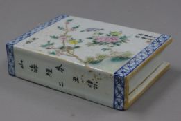 A small Chinese porcelain pillow decorated with calligraphy. 14 cm long.