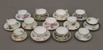 A collection of miniature porcelain cups and saucers, including Royal Worcester.