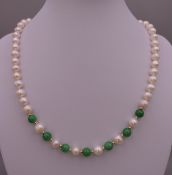 A jade and pearl necklace with a 14 ct gold clasp. 44 cm long.