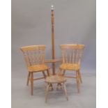 An Ercol elm seated child's chair, two pine kitchen chairs and a standard lamp.