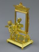A gilt bronze cherub mirror. 23 cm high.