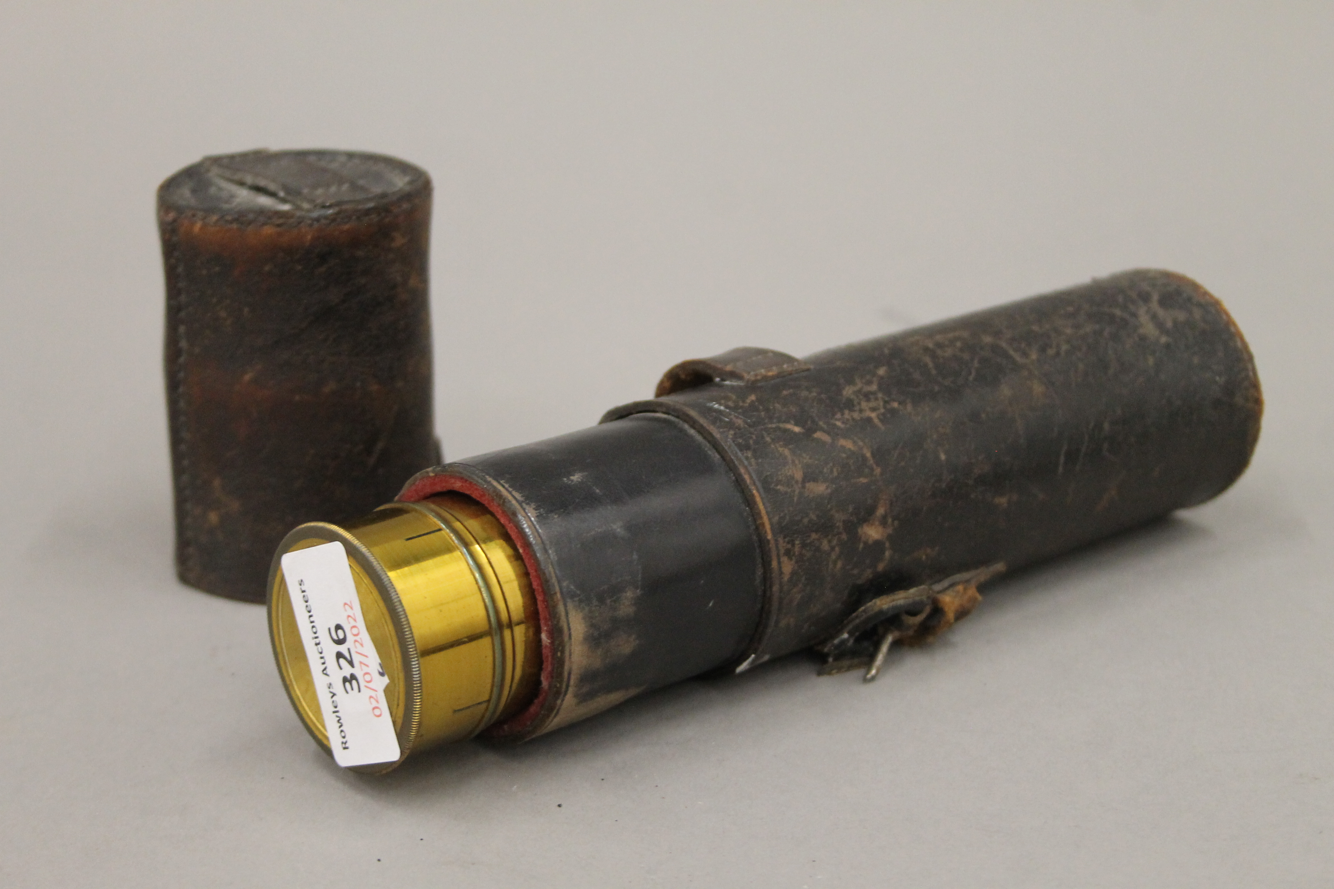 A leather cased brass telescope. 22.5 cm long closed.