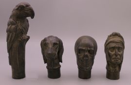 Four bronze walking stick tops formed as a dog's head, a Native American, a skull and a parrot.