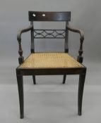 A 19th century cane seated mahogany open armchair. 53 cm wide.