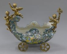 A bronze and porcelain cherub centrepiece. 43 cm wide.