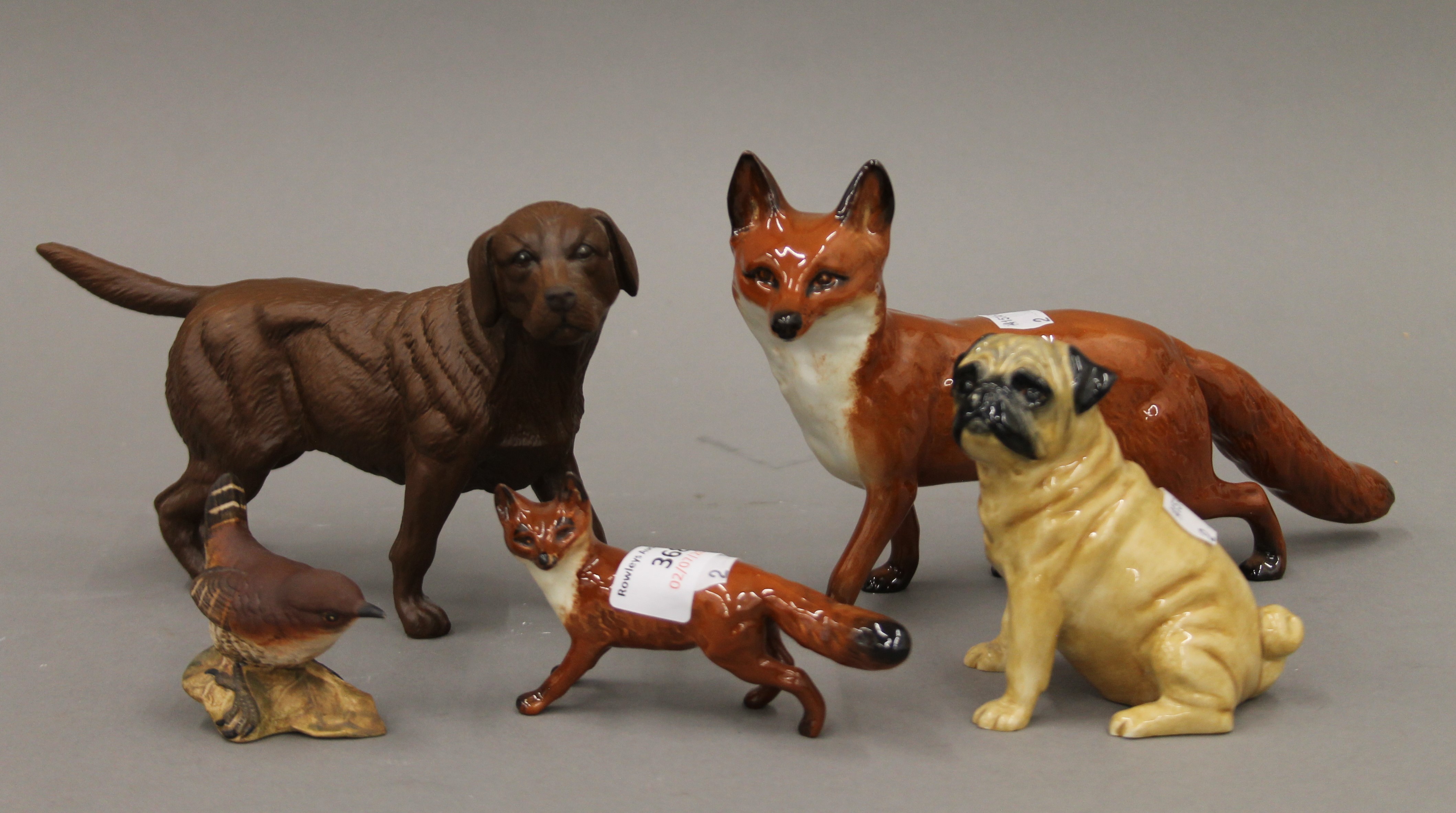 Two Beswick foxes, a pug dog, a wren and a Doulton dog.