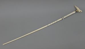 A 19th century whale bone walking stick with carved marine ivory handle formed as a walrus. 92.