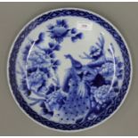 A 19th century Chinese blue and white porcelain charger decorated with a peacock and flowers. 30.