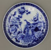 A 19th century Chinese blue and white porcelain charger decorated with a peacock and flowers. 30.