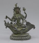 A bronze multi-armed deity modelled seated on a mythical beast. 25 cm high.