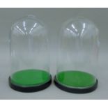 A pair of vacant glass domes. Each 30 cm high.