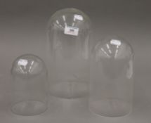 Two glass domes and a plastic dome. The glass domes 25 cm high and 14 cm high.