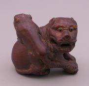 A wooden dog-of-fo form carving. 3.5 cm high.