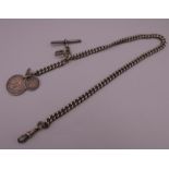 A silver Albert chain set with coins and Hindu pendant. Chain 38 cm long.