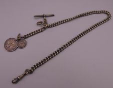 A silver Albert chain set with coins and Hindu pendant. Chain 38 cm long.