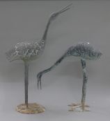 A pair of models of cranes. The largest 87 cm high.