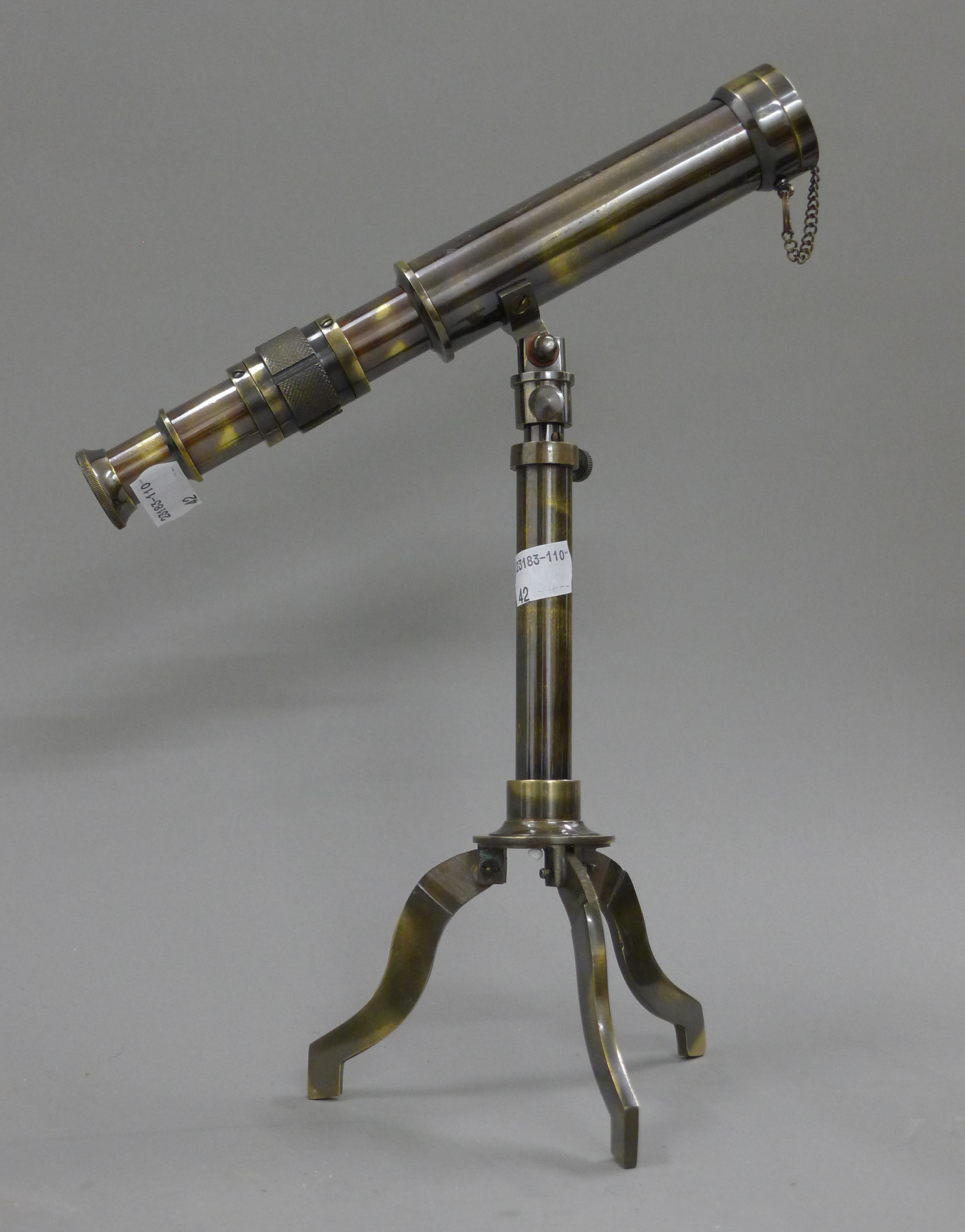 A small telescope on stand. 25 cm long.
