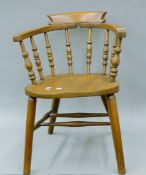 A Victorian elm seated smokers bow armchair. 56 cm wide.