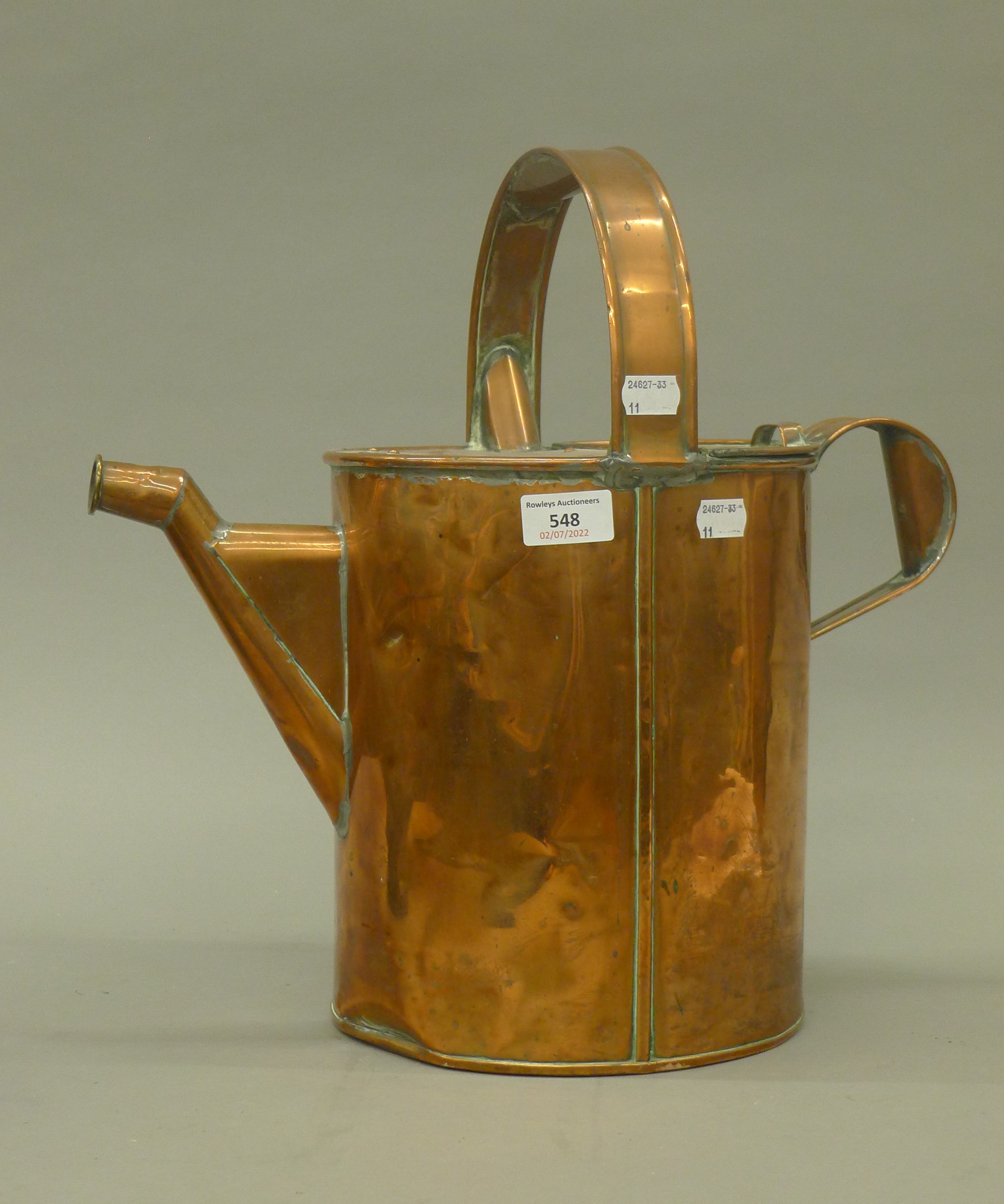 An antique copper watering can. 40 cm high.