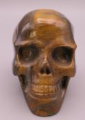 A tigers eye type model of a skull. 5 cm high.