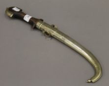 An Eastern Jambiya in scabbard. 40 cm long.