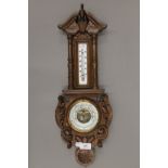 A Victorian carved oak barometer. 56.5 cm high.