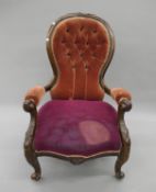 A Victorian upholstered button back open armchair. 66 cm wide.