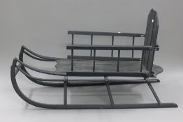 A black painted wooden sledge. 76 cm long.