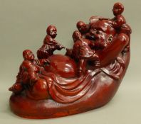 A large red resin model of Buddha. 35 cm long.