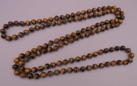 A string of tigers eye beads. Approximately 126 cm long.
