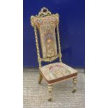 A Victorian prie dieu gilt chair with needlework upholstery. 117 cm high.