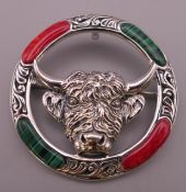 A silver bull's head form brooch. 4 cm diameter.